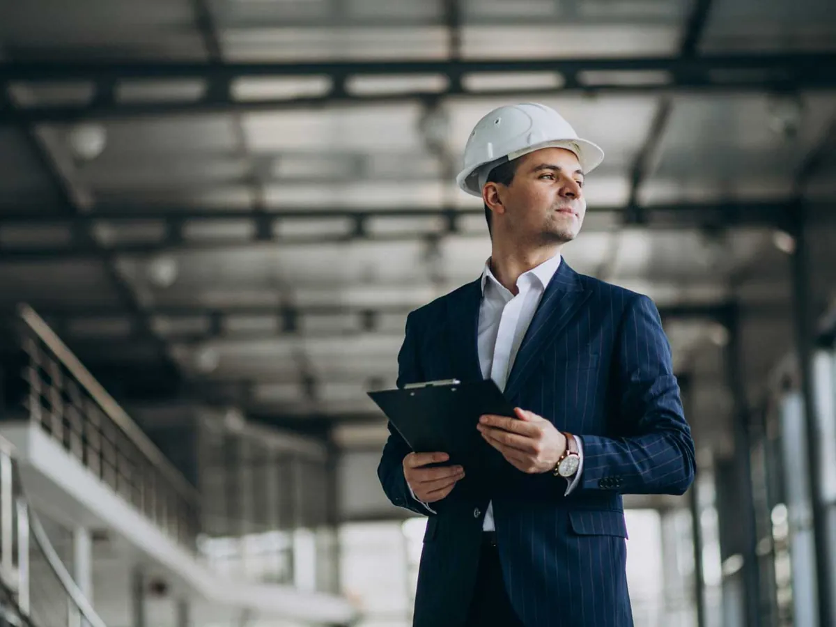 Engineer with a clipboard inspecting an industrial plant room