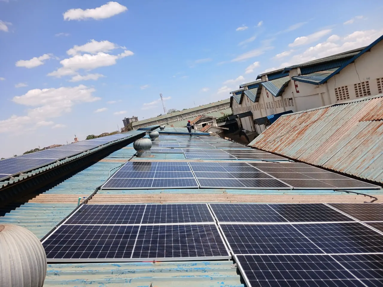 Rows of solar PV panels across the roof of an industrial building